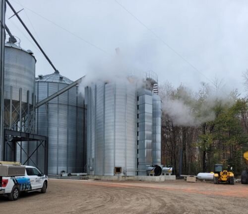 Grain bin dryer system releasing steam during operation
